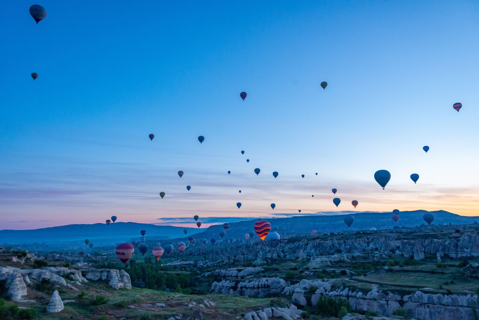 Fairy chimneys and hot-air balloons over Cappadocia at sunrise